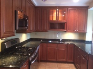 Modern kitchen with granite countertops, stainless steel appliances, five burner stove and Bosch dishwasher.